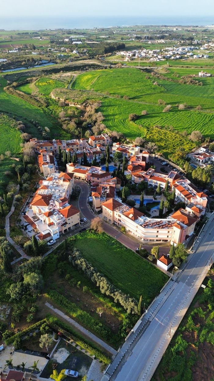 A scenic aerial view of a charming village surrounded by lush greenery in Cyprus.